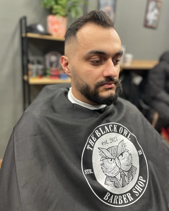 Quiff και γένια, με τη μαύρη κάπα με την κουκουβάγια